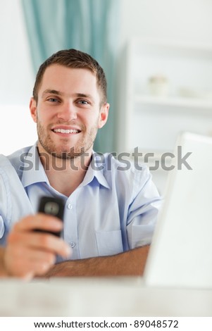 Smiling young businessman with his cellphone
