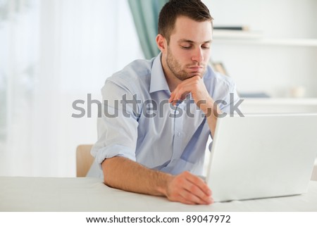 Young businessman reading an e-mail on his laptop