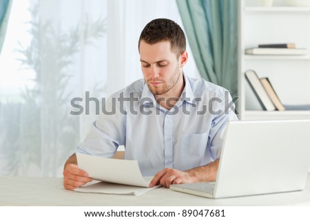 Young businessman reading a letter in his home office