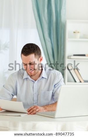Smiling young businessman reading a letter