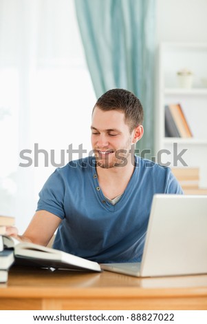 Male student using the internet for his book report