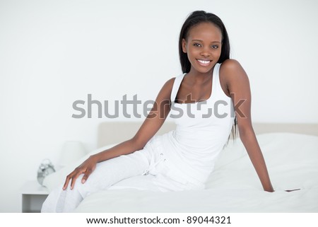 Woman posing on her bed while looking at the camera