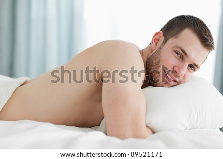 Calm man lying on his belly in his bedroom