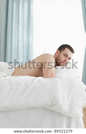 Portrait of a calm man lying on his belly in his bedroom