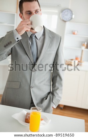 Portrait of an attractive businessman having breakfast in his kitchen