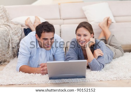 http://image.shutterstock.com/display_pic_with_logo/76219/76219,1322508027,91/stock-photo-couple-watching-a-movie-with-a-laptop-while-lying-on-a-carpet-90152152.jpg