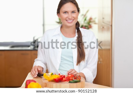 Lovely woman slicing a pepper in her kitchen