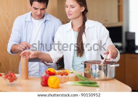 Cute couple using a tablet computer to cook in their kitchen
