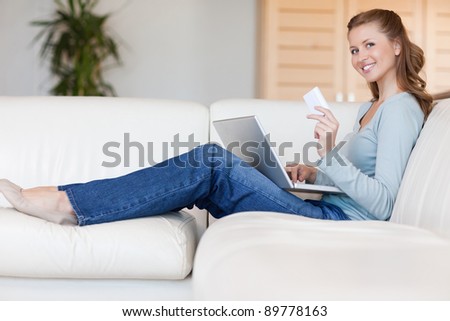 Young woman sofa placing an order online