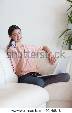 Portrait of a delighted woman shopping online in her living room