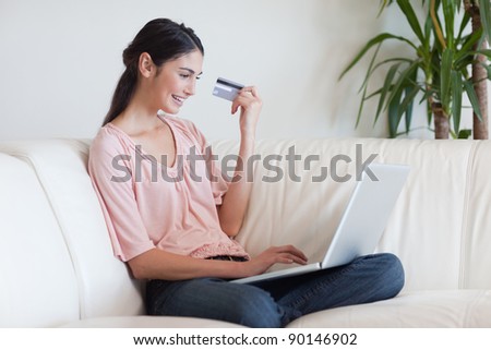 Smiling woman shopping online in her living room
