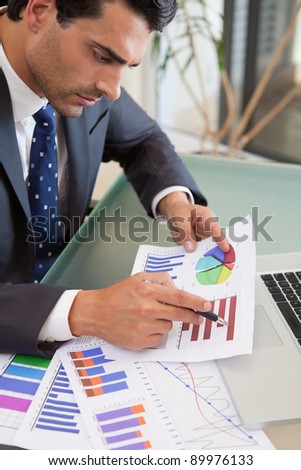 Portrait of a young sales person studying statistics in an office