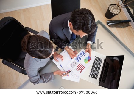 Young sales persons studying statistics in an office