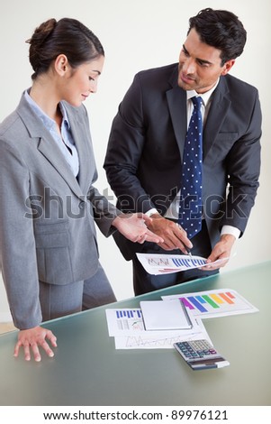 Portrait of sales persons studying their results in an office