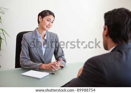 Manager interviewing a good looking applicant in her office