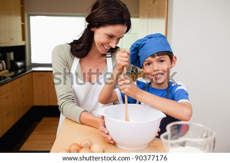 Mother and son having fun preparing a cake together