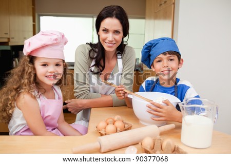 Mother and her children preparing cake together