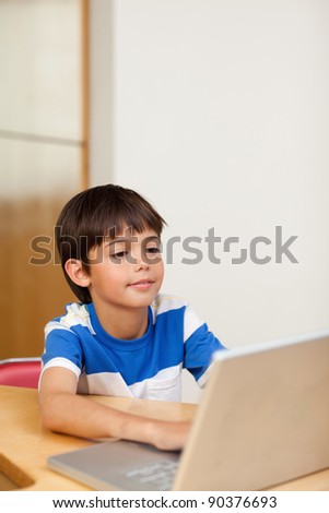 Little boy playing computer games on the laptop