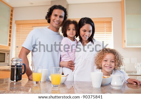 Happy young family having breakfast in the kitchen together