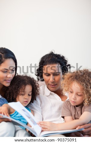 Young family on the couch looking at photo album together