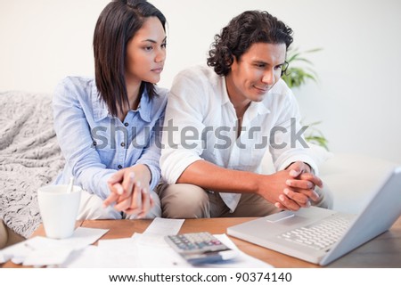 Young couple sitting in the living room doing online banking