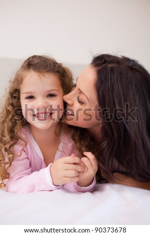 Young mother kissing her daughters cheek