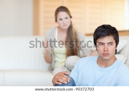 Upset couple arguing in their living room