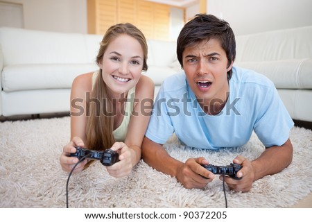 Playful couple playing video games in their living room