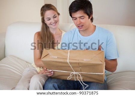 Young couple looking at a package in their living room