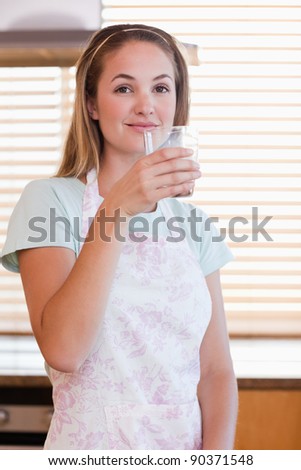 Portrait of a woman drinking milk in her kitchen