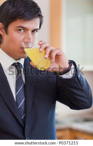 Portrait of a businessman drinking orange juice in his kitchen