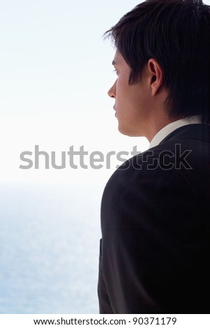 Portrait of a businessman day dreaming while looking at the sea
