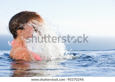 Young woman raising her head out of the water in a swimming pool