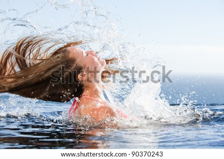 Beautiful woman raising her head out of the water in a swimming pool