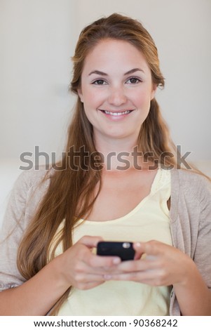 Smiling young woman holding her cellphone