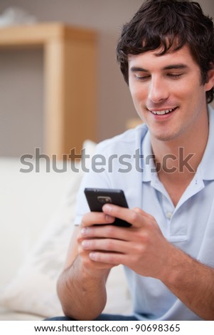 Smiling young man writing textmessage