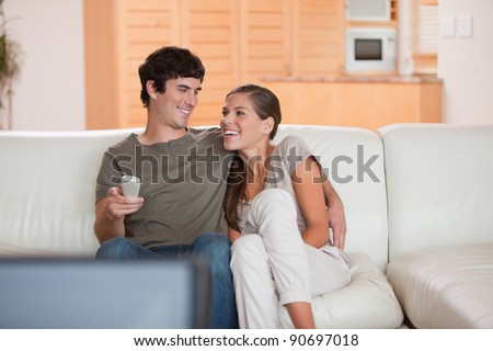 Laughing young couple watching funny movie together