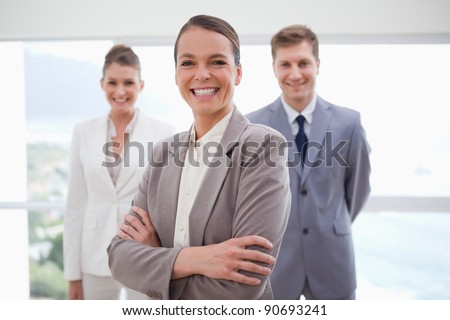 Smiling business consultant with arms folded together with her team