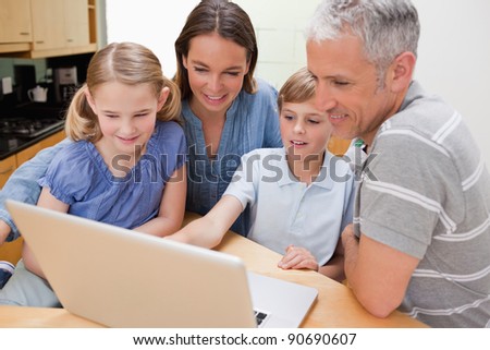 Lovely family using a notebook in their kitchen