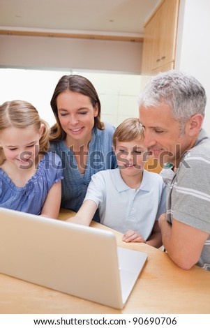 Portrait of a lovely family using a notebook in their kitchen