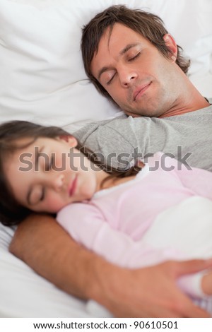 Portrait of a calm father sleeping with his daughter in a bedroom