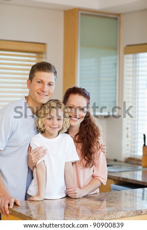 Cheerful family standing behind the kitchen counter together