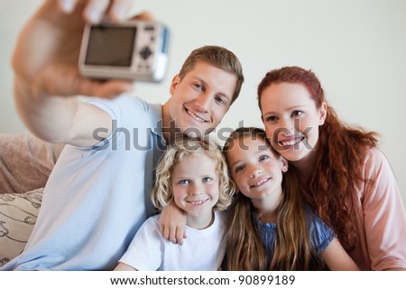 Father taking a family picture on the sofa