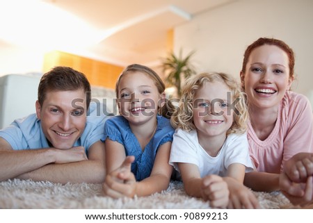 Cheerful smiling family on the carpet