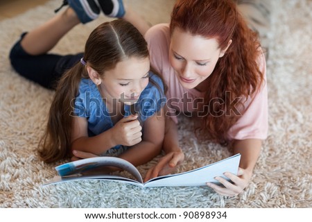 Mother and daughter on the carpet reading together