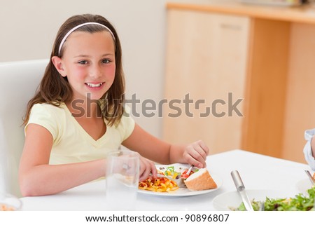 Smiling girl having dinner at the dinner table