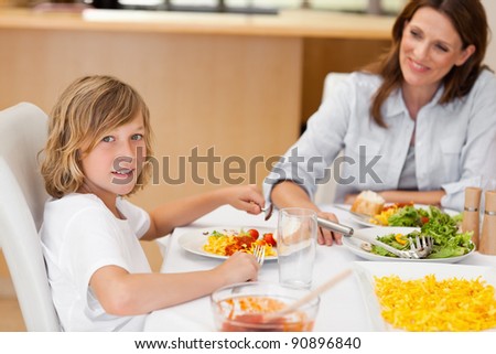 Side view of smiling boy sitting at the dinner table