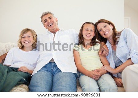 Laughing family sitting on the couch together