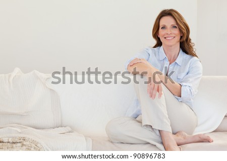 Smiling mature woman sitting on her sofa