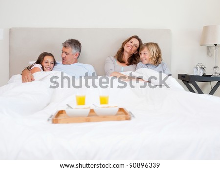 Family about to have breakfast in bed together